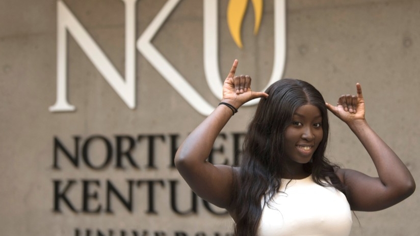 Student in front of NKU sight doing a Norse Up